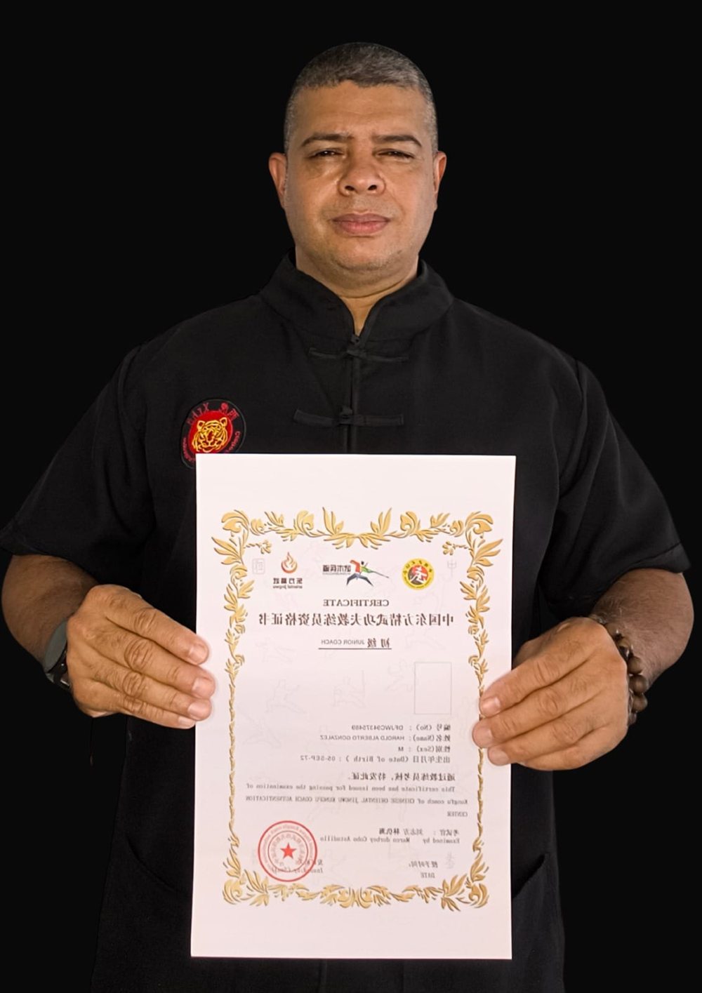 Harold Alberto González Paz con su certificado de instructor y el emblema del tigre de XIHU